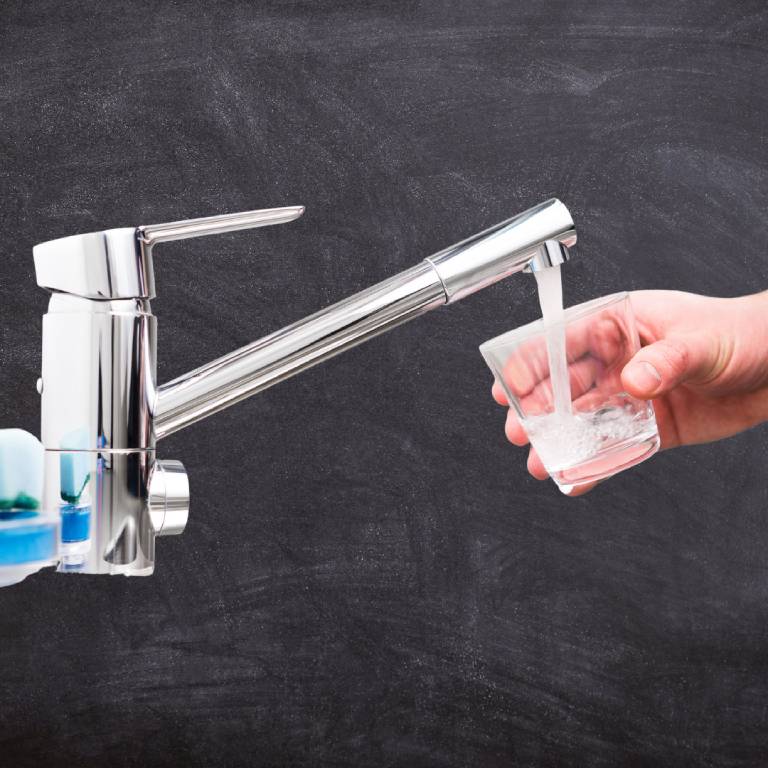 A person is holding a glass of water in their hand.